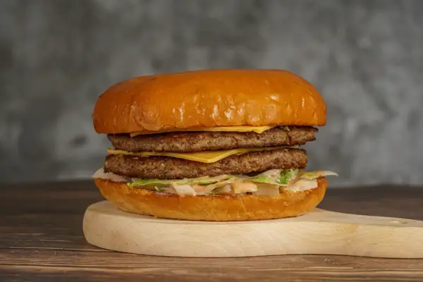 A double beef burger with cheese in a glazed bun